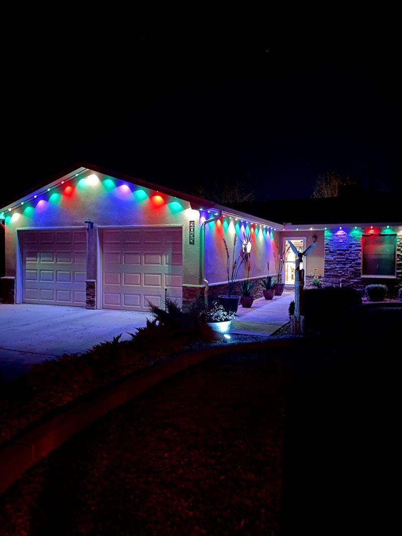 Traditional C9 Christmas bulbs clipped along a roofline for comparison