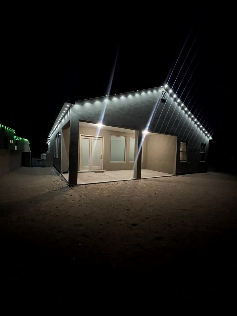 Cool white permanent eave lighting outlining the peaks of a stucco home
