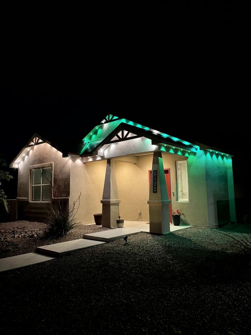 Permanent holiday lighting switched to a green scene on an Albuquerque house
