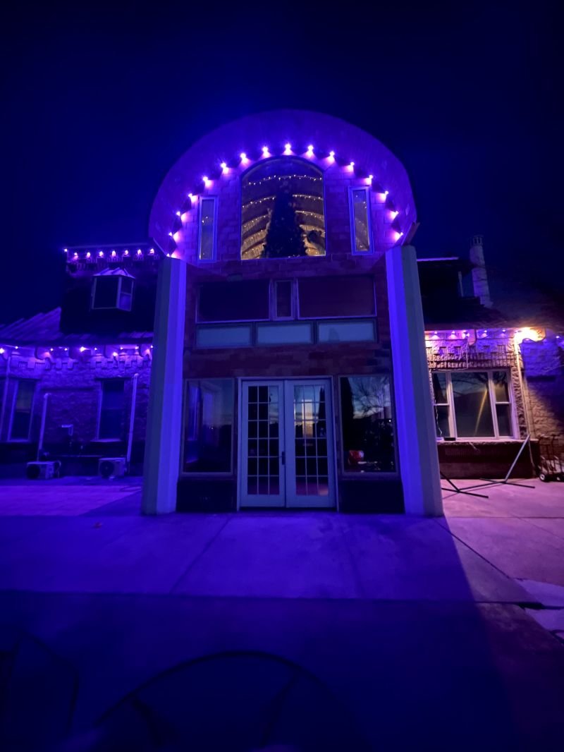 Permanent lighting set to a deep blue scene across a two-story home