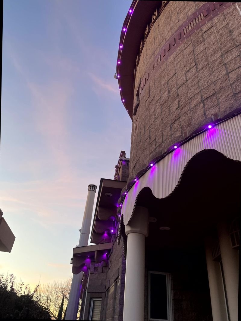 Close-up of permanent lighting track mounted under the eave of a brick Albuquerque home at dusk