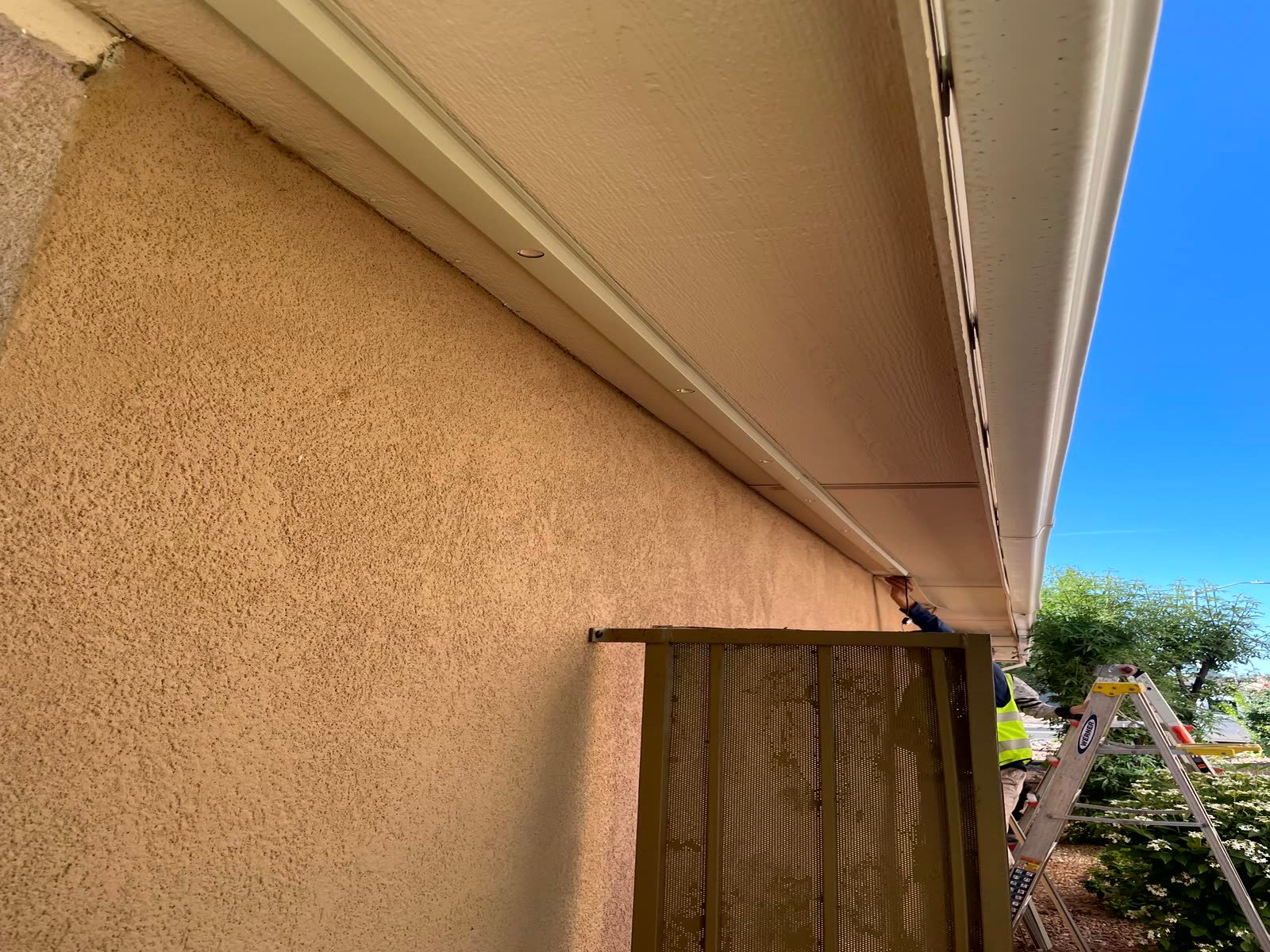 Permanent lighting channel color-matched to the fascia and running the full eave of an Albuquerque home, barely visible in direct daylight