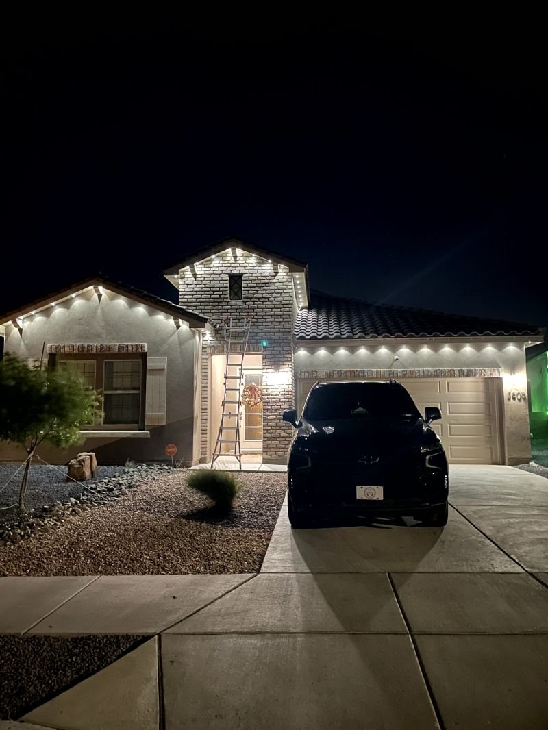 Permanent outdoor lighting washing the stucco and entry of an Albuquerque home in warm white
