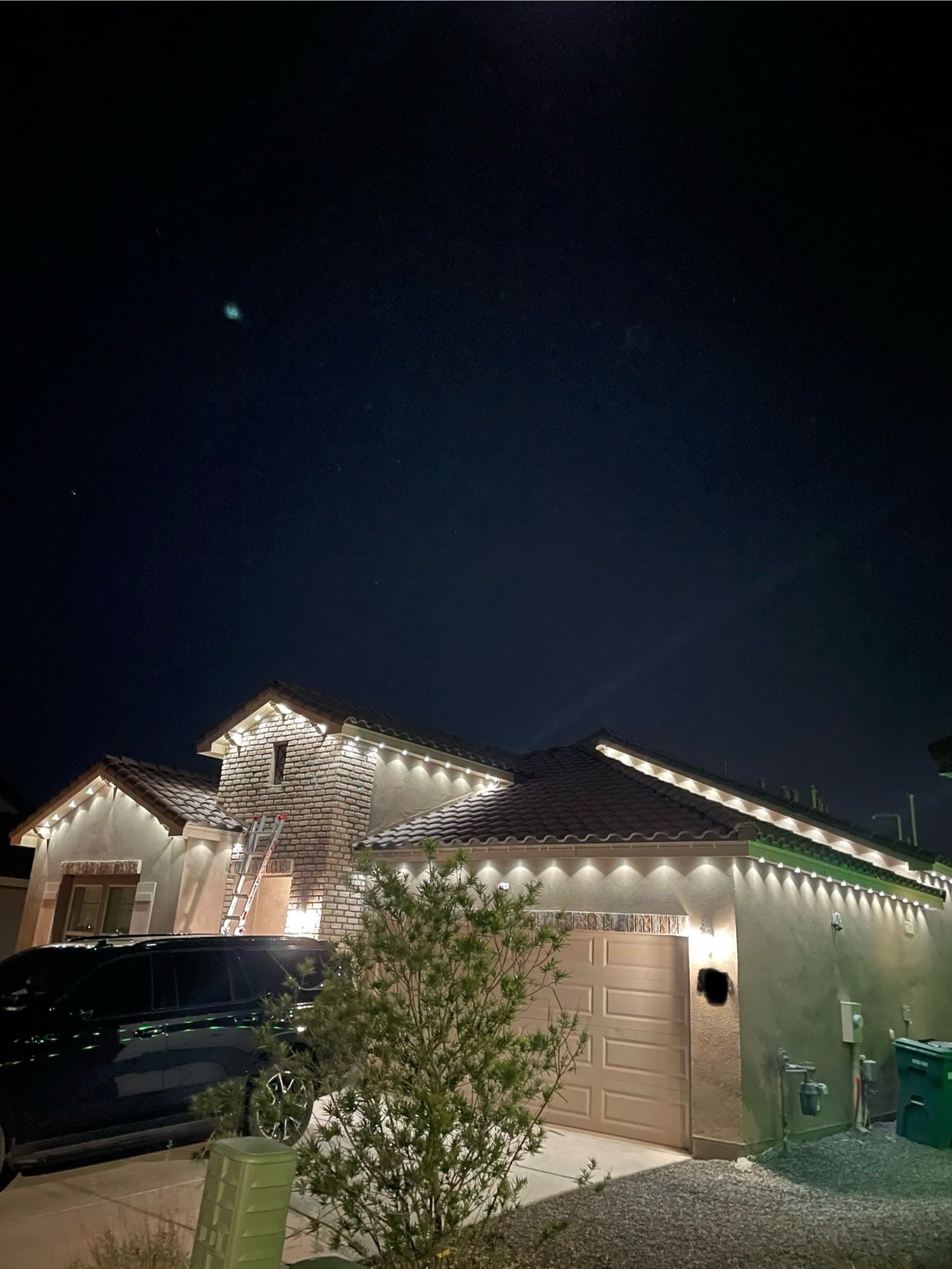 Warm white permanent roofline lighting on a tile-roofed Albuquerque home at night